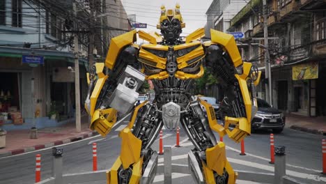 Langsame-Filmische-Dolly-Out-Aufnahme-Einer-Riesigen-Bumblebee-Transformers-Figur,-Die-Mitten-Auf-Einer-Kreuzung-In-Chinatown,-Bangkok,-Thailand,-Steht