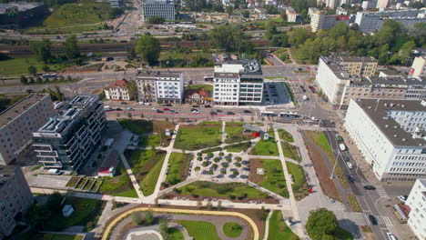 Bird's-eye-view-of-Central-Park-in-Gdynia,-highlighting-a-blend-of-urban-architecture-and-manicured-green-spaces,-with-bustling-streets-and-buildings-surrounding