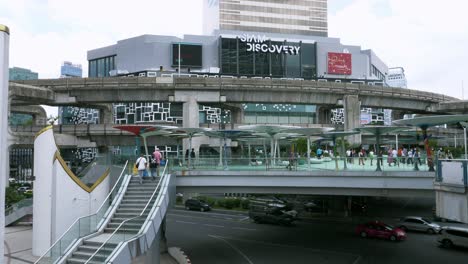 Tourists-and-shoppers-walking-on-the-elevated-walkway-that-connects-MBK-to-Siam-Discovery-Mall,-in-Pathum-Wan-District-in-Bangkok,-Thailand