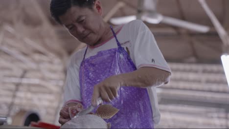 Experienced-Fishmonger-Expertly-Scaling-Fresh-Catch-at-a-Vibrant-South-East-Asian-Seafood-Market-in-Malaysia