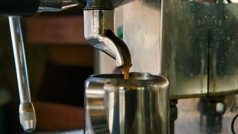 Nahaufnahme-Des-Kaffees,-Der-In-Zeitlupe-In-Eine-Teetasse-Aus-Metall-Tropft