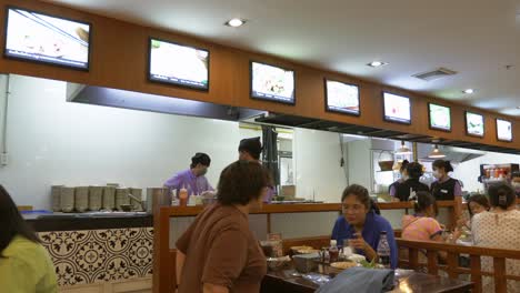 Los-Comensales-Añaden-Condimentos-A-Su-Plato-De-Fideos-Picantes-Y-Picantes-Y-Comen-Con-Un-Par-De-Palillos-En-Un-Restaurante-Local.