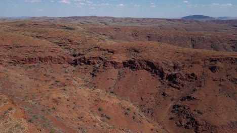 Aerial-wide-shot-showing-beautiful-desert-mountains-in-Karijini-National-Park-during-sunny-day,-Australia