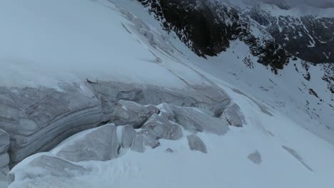 A-drone-hovers-above-a-glacier,-revealing-intricate-crevasses