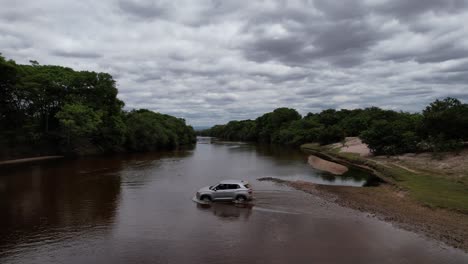 drone-video-of-a-car-crossing-river,-Vale-do-Pati,-Chapada-Diamantina,-Bahia,-Brazil