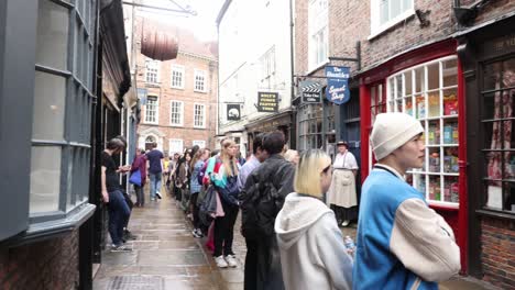 Handschwenk,-Der-Die-Schlange-Vor-Den-Geisterhändlern-In-The-Shambles,-York-Zeigt