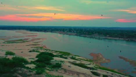 Amazing-sunset,-the-dry-Amazon-sand-banks-below-and-birds-in-flight-above