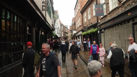 Toma-En-Mano-De-Turistas-Caminando-Por-El-Bullicioso-Caos-Histórico-De-York.