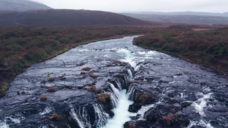 Aerial:-Flyover-Bruarfoss-cascading-waterfall-off-the-golden-circle-in-southern-Iceland-that-is-very-picturesque-with-the-beautiful-blue-cascade-of-falls-into-the-plunge-pool-below