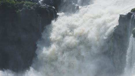 Iguazu-Falls-Waterfall-in-Argentina,-Iguacu-Falls-Waterfalls-Pouring-off-Tall-Rocky-Cliff,-Falling-Water-off-Huge-Cliff-in-Argentinian-Rainforest,-Detailed-Large-Splashing-Waterfall-in-South-America