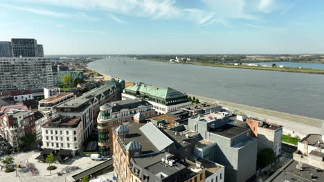 Aerial-view-showing-neighborhood-in-Antwerp-with-modern-blocks-and-Schelde-River-during-sunny-day