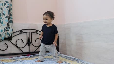 cute-toddler-baby-boy-trying-to-stand-for-the-first-time-at-bed-at-home