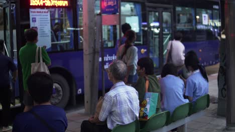 Eine-Gruppe-Einheimischer-Wartet-Geduldig-An-Einer-Bushaltestelle-In-Bangkok-Auf-öffentliche-Verkehrsmittel
