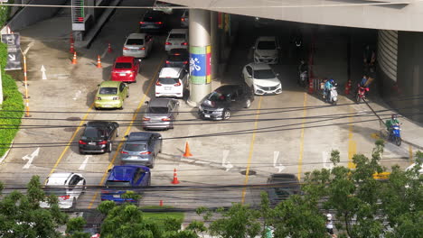 Coches-Y-Otros-Vehículos-Que-Entran-Y-Salen-De-Un-Edificio-O-De-Un-Centro-Comercial-Para-Aparcar-Y-Salir,-Como-Se-Ve-En-Bangkok,-Tailandia.