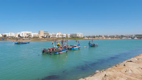 Fish-boats-docked-in-emerald-water-in-Rabat,-Morocco,-panning-establisher-shot