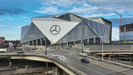 Toma-Aérea-Hacia-Atrás-Que-Muestra-El-Cruce-Con-El-Vehículo-Frente-Al-Mercedes-Benz-Arena-En-La-Ciudad-De-Atlanta.