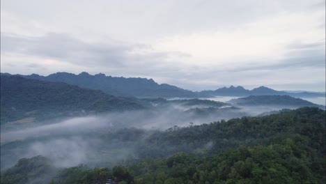 Mystical-Morning-Fog-covering-Magelang-Mountains-in-Bali,-Aerial-Sunrise-Drone-Flight