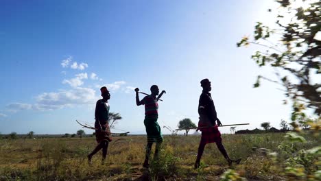 Indigenous-Warriors-From-The-Karamojong-Tribe-Walking-Through-The-Savannah-In-Northern-Uganda-In-Africa
