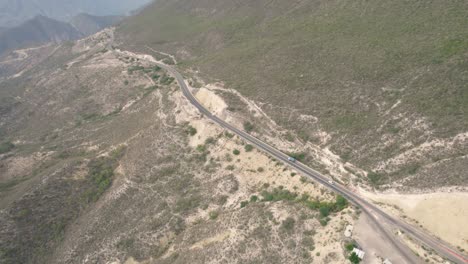Luftaufnahme-Mehrerer-Lastwagen,-Die-Sich-Entlang-Einer-Straße-In-Der-Nähe-Der-Berge-In-Mexiko-Bewegen