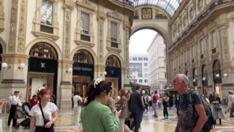 cinematic-video-of-two-young-man-walking-through-the-Galleria-Vittorio-Emanuele-shopping-centre-in-the-centre-of-Milan-in-italy-during-a-hot-and-sunny-week-day