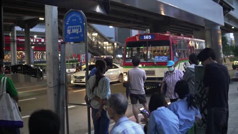 A-group-of-people-are-waiting-patiently-at-a-bus-stop-in-Bangkok-for-public-transportation