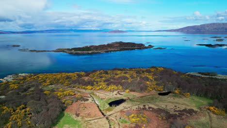 Scenic-coastal-views-off-the-coast-of-Skye-Island-Scotland,-calm-Atlantic-ocean-waters-reflect-cloudy-sky