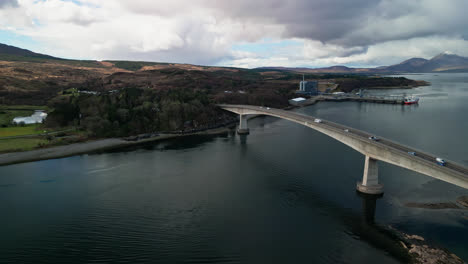 Autos-Fahren-über-Die-Skye-Brücke-In-Schottland,-Während-Das-Wasser-Wolken-Und-Die-Brücke-Darüber-Reflektiert