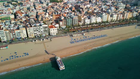 Lloret-De-Mar,-from-the-air-view-of-the-passenger-boat-over-the-Town-Hall,-on-the-Costa-Brava-of-Gerona,-beautiful-tidy-beach