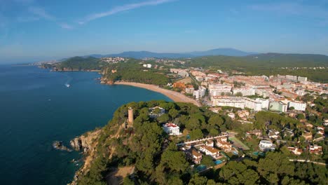 aerial-views-of-the-coast-and-cliffs-of-Fenals-on-the-Costa-Brava-of-Gerona,-Lloret-De-Mar,-urbanizations-and-vegetation