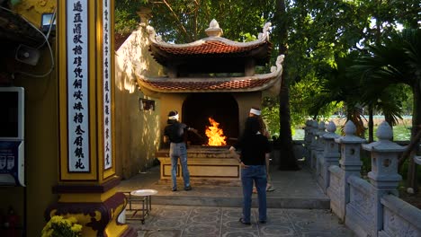 La-Costumbre-De-Quemar-Papel-Joss-En-El-Templo-De-La-Pagoda-De-Trac-Quoc,-Vietnam