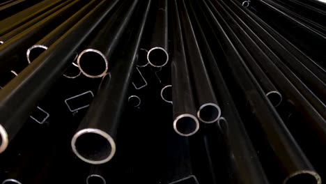 Pile-of-black-Pipes-in-industrial-warehouse