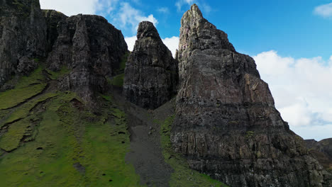 Drone-rises-along-landslide-chutes-and-grassy-hills-below-sheer-cliffs-in-the-Scottish-highlands