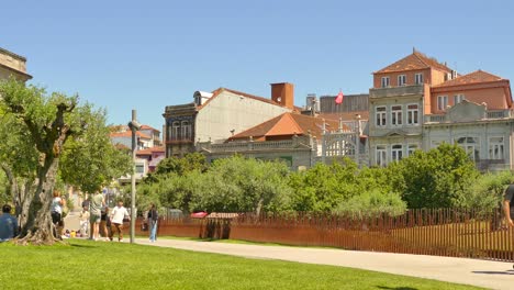 Tourists-walking-near-the-square-with-Olive-tree-area-in-Porto,-Portugal