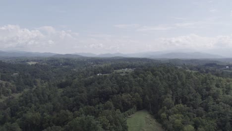 Aerial-drone-footage-features-serene-forests,-charming-farm-fields,-and-rolling-hills