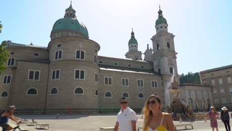 Lovely-Couple-Walks-Into-a-Frame-Near-Salzburg-Cathedral-on-a-Sunny-Day