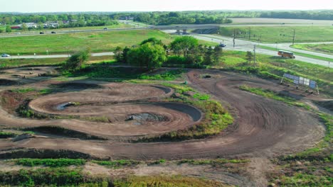 A-Motocross-Track-Located-On-A-Busy-State-Road,-Aerial-View
