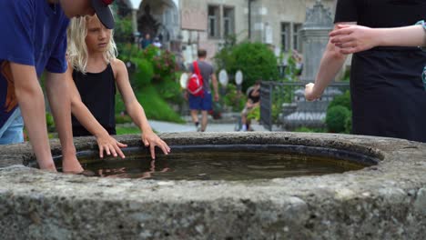 Family-of-Four-Washes-Their-Hands-in-Water-Basin-that-is-Placed-in-St