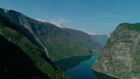 Vista-Aérea-Del-Majestuoso-Paisaje-Montañoso-De-Noruega-Cerca-De-Aurland-Con-Un-Río-Azul-Que-Fluye-A-Través-Del-Valle-Durante-Un-Viaje-Impresionante