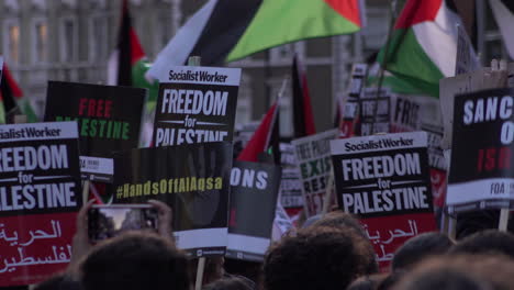 Eine-Person-Filmt-Mit-Einem-Smartphone-Eine-Menge-Plakate,-Während-Sich-Am-Abend-Hunderte-Menschen-Auf-Der-Straße-Vor-Der-Israelischen-Botschaft-In-London-Zu-Einer-Protestkundgebung-Versammeln