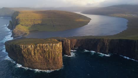 Very-far-rising-drone-footage-of-the-Leitisvatn-Lake,-aka-the-Floating-Lake,-on-the-Vagar-island-in-the-Faroe-Islands