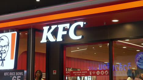 Close-up-of-KFC-Kentucky-fried-chicken-fast-food-restaurant-logo-in-MBK-center-Bangkok-shopping-mall,-Thailand