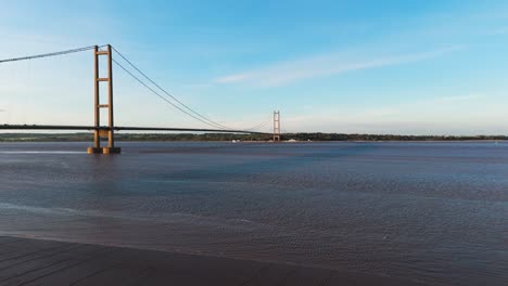 Aerial-spectacle:-Humber-Bridge-bathed-in-the-glow-of-the-sunset,-cars-in-rhythmic-motion