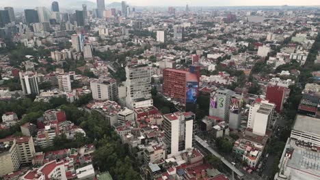 Vista-Aérea-De-La-Avenida-Insurgentes,-En-El-Sur-De-La-Ciudad-De-México,-Se-Puede-Ver-El-Edificio-Canadá-Con-Una-Pintura-Monumental