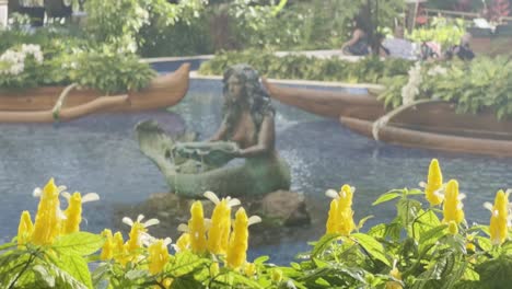 Cinematic-panning-shot-of-colorful-flowers-to-a-mermaid-sculpture-in-the-lobby-of-the-Grand-Wailea-luxury-resort-in-Maui,-Hawai'i