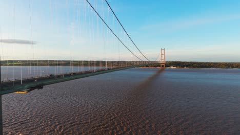The-art-of-movement:-An-aerial-view-of-Humber-Bridge-at-sunset,-where-cars-contribute-to-a-breathtaking-visual-composition