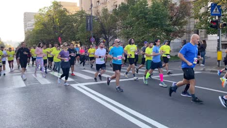 Corredores-De-Maratón-Con-Camisas-Verdes-De-Color-Amarillo-Brillante-Corren-Sobre-Asfalto-En-El-Centro-De-La-Ciudad-Temprano-En-La-Mañana