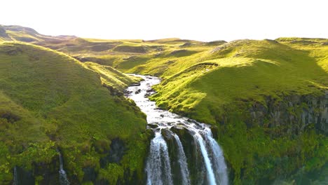 En-La-Cima-De-Una-Cascada-De-Skógafoss-En-Islandia,-El-Agua-Fluye-Sobre-Una-Exuberante-Meseta-Verde-De-La-Naturaleza
