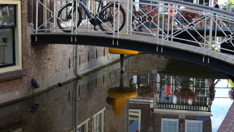 Bicicleta-En-El-Puente-Peatonal-Hasta-La-Entrada-De-La-Quesería-Junto-Al-Canal-En-Gouda,-Países-Bajos