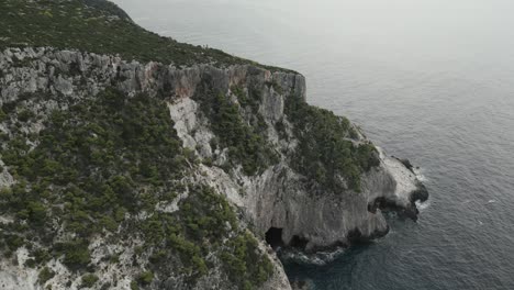 Luftdrohnenvideo-Des-Ikonischen-Geologischen-Phänomens-Der-Blauen-Höhlen-Auf-Der-Nördlichen-Insel-Zakynthos-Mit-Tief-Saphirblauer-Felsiger-Meereslandschaft