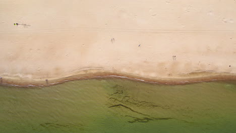 Panoramablick-Auf-Den-Strand-Von-Jelitkowo-In-Danzig,-Mit-Smaragdgrünem-Wasser,-Fahrzeugspuren-Im-Sand-Und-Menschen-Am-Strand